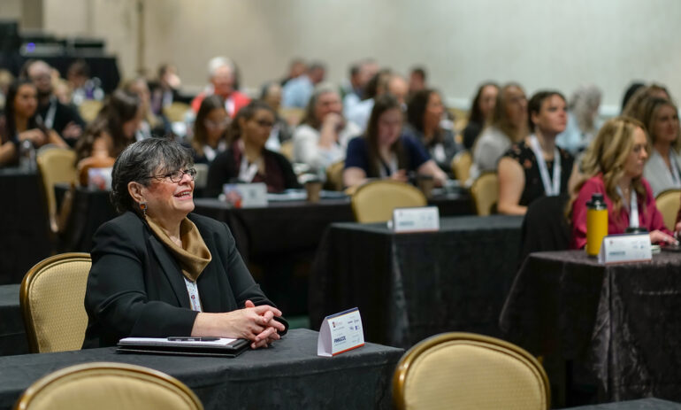Female attendee smiling in the crowd
